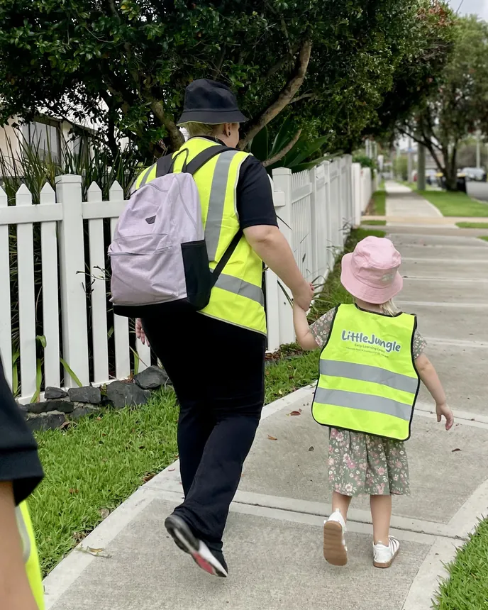 Educator walking hand in hand with a child through Dundas