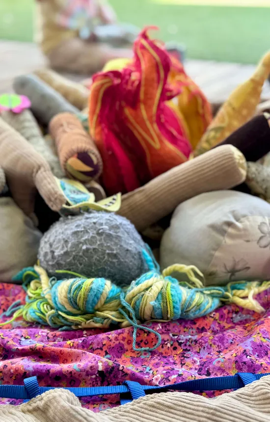 Loose parts play set out with soft stones and fabric
