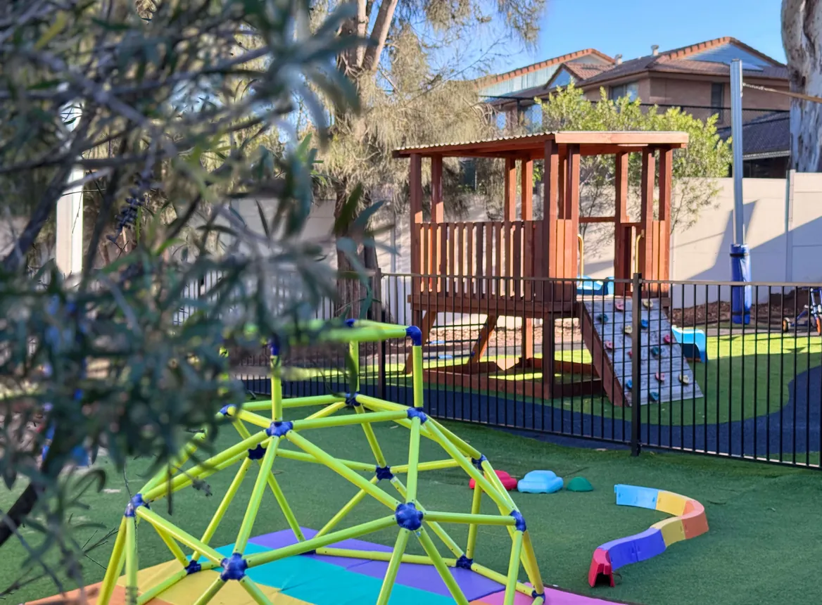 Outdoor yard with the green climbing dome and the cubby fort
