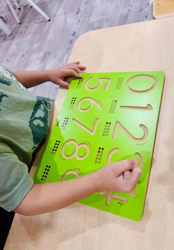 A child tracing numbers on a number board