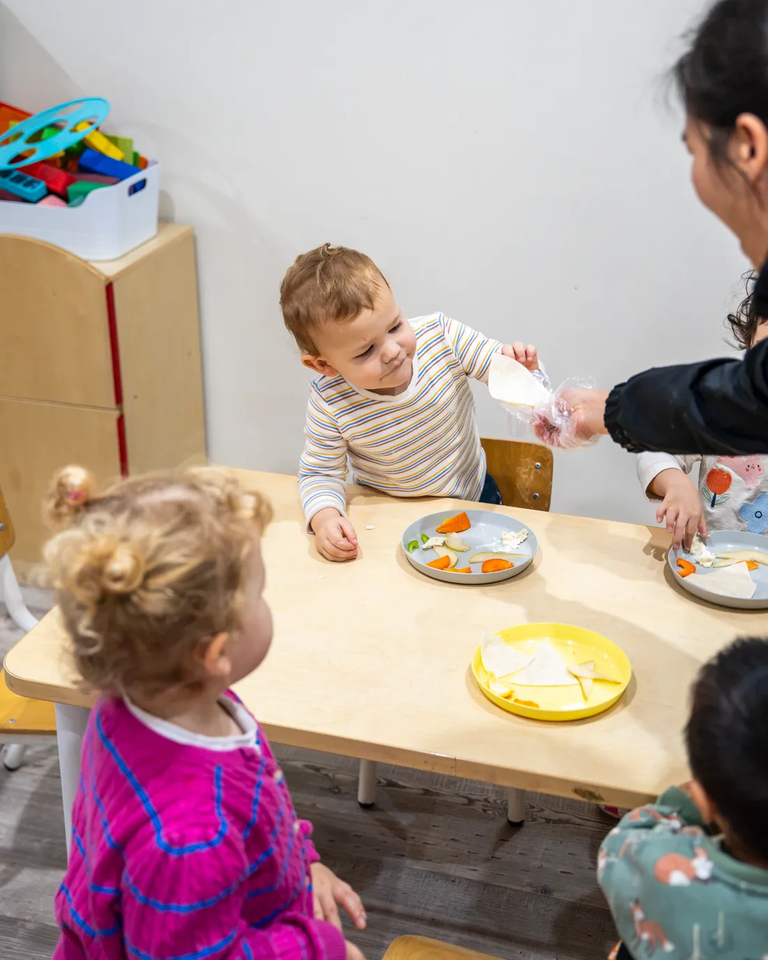 Educator serving a meal at a low table at Little Jungle Dundas