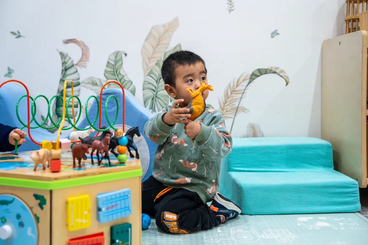 Baby exploring an activity cube in the Cuddle Cubs room, Little Jungle Dundas