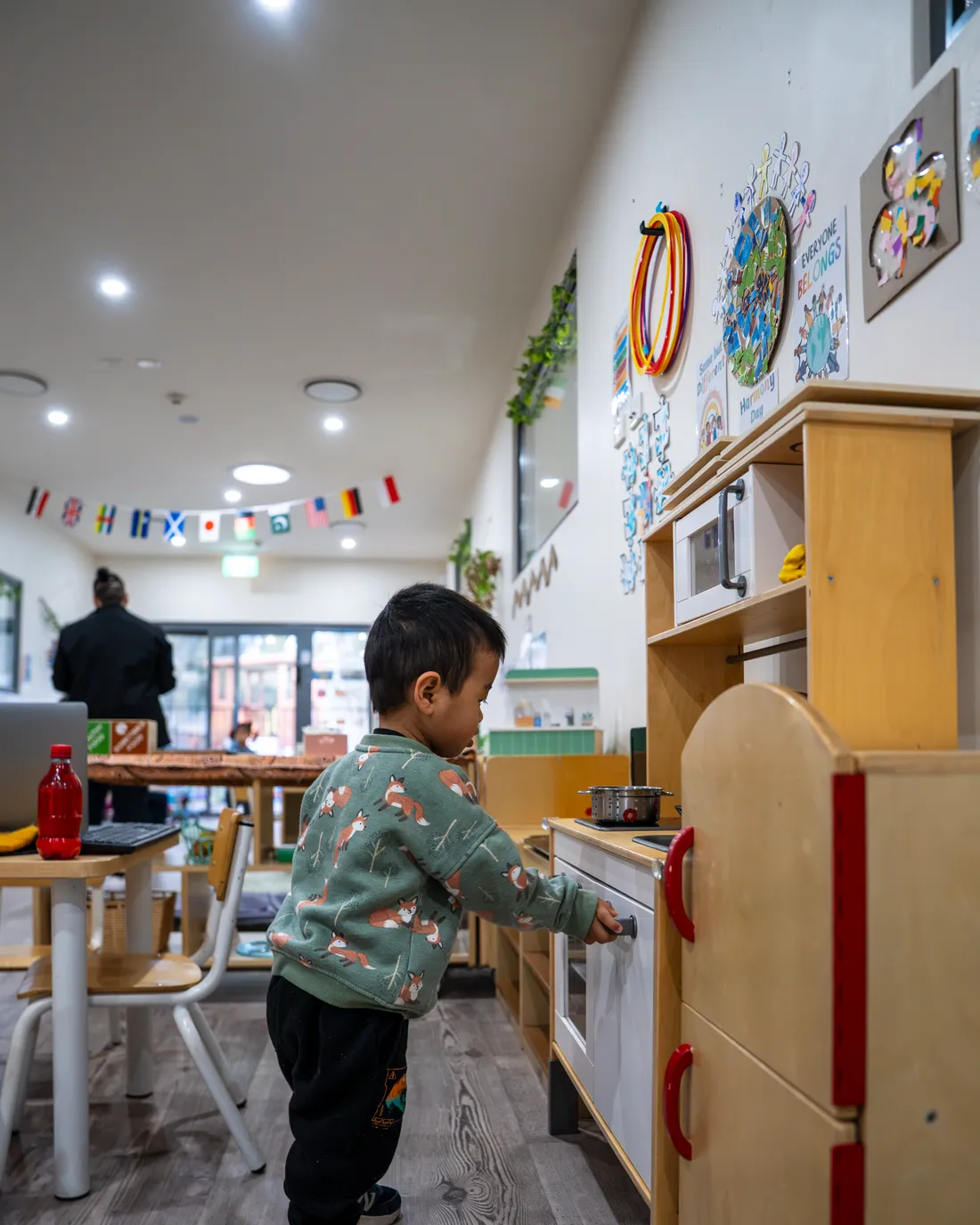 Child at the play kitchen with a long view down the room, Little Jungle Dundas